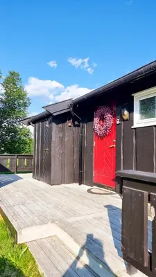 a building with a red door and a fence at Skurdalsvegen 37L in Geilo