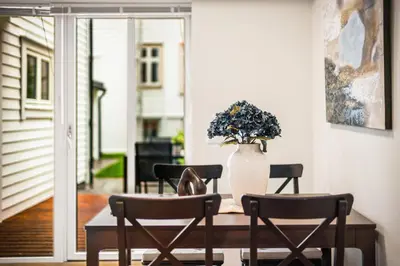 a table with chairs and a vase with flowers on it at Corner Apartments in Bergen