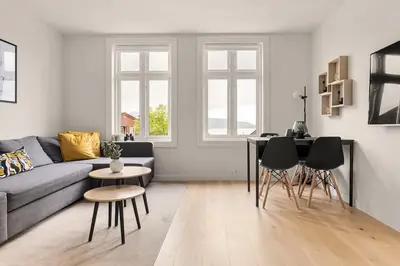 a living room with a couch and a table and chairs at Dinbnb Apartments I Views & Street Parking in Sandviken in Bergen