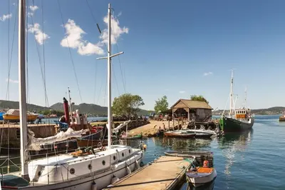 a group of boats docked at a dock in the water at Dinbnb Apartments I Views & Street Parking in Sandviken in Bergen