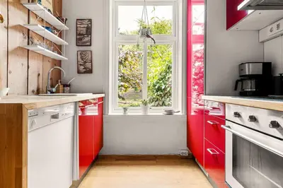 a kitchen with red cabinets and a window at Dinbnb Apartments I Characteristic Townhouse with Bathtub in Bergen