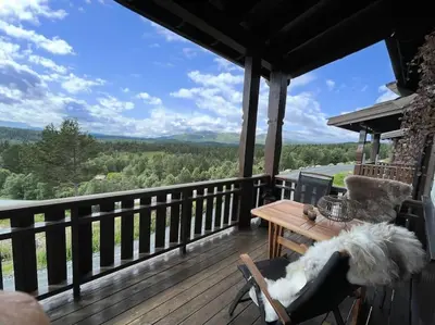 a wooden deck with a table and a view of the mountains at Leilighet i vakre Rauland in Rauland