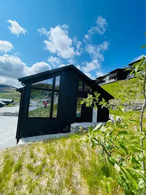 a black house on top of a grassy hill at Hodlekvevegen 308 - Flott hytte midt i skisenteret in Sogndal