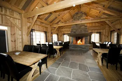 a dining room with tables and a fireplace at Grindastugu cabin right by Liatoppen Ski Centre. in Ål