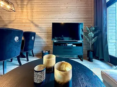 a living room with a table and a flat screen tv at New high standard apartment in Trysil with ski in out in Trysil