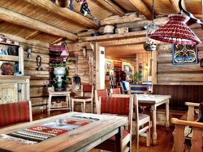 a dining room with wooden walls and a table and chairs at Smuksjøseter Fjellstue in Høvringen