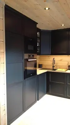 a kitchen with black cabinets and a sink at Stor og koselig hytte i Stryn in Stryn