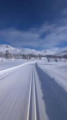 a road covered in snow with mountains in the background at Stor og koselig hytte i Stryn in Stryn