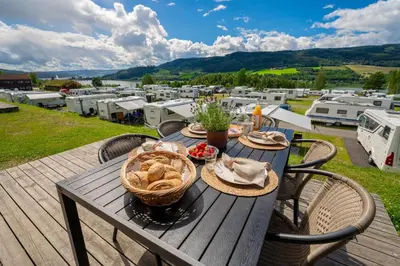 a table with a basket of food on a deck with rvs at Lillehammer Turistsenter Camping in Lillehammer