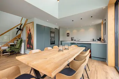 a dining room with a wooden table and chairs at Modern house by the Fjord in Sandane, Nordfjord. in Sandane