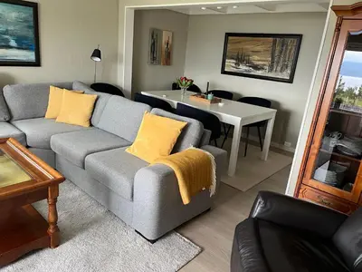 a living room with a couch and a table at Sjarmerende og romslig bolig, omgitt av vakker natur in Molde