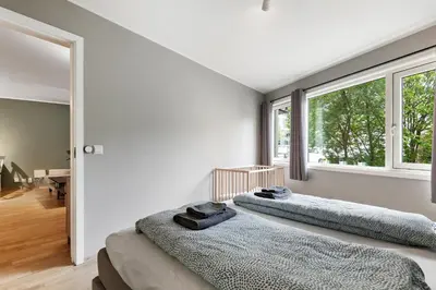 two beds in a room with two windows at Modern and central apartment in Bergen in Bergen