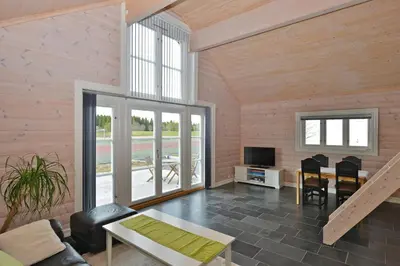 a living room with wooden walls and a large window at Elton Hotel in Raufoss
