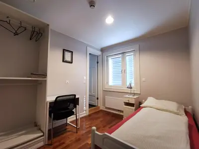 a bedroom with a bed and a desk and a window at Elton Hotel in Raufoss