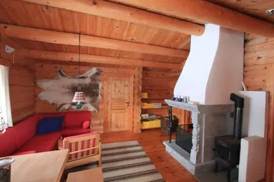 a living room with a red couch and a fireplace at Lusæter Timber Cabins in Heidal