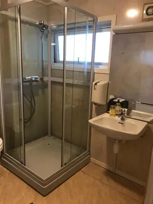 a bathroom with a shower and a sink at Leirvik Vandrehjem in Leirvik