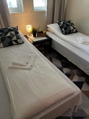 two beds sitting next to each other in a room at Leirvik Vandrehjem in Leirvik
