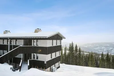 a building on top of a snow covered mountain at Hafjell Front 220D 8pers, Ski inout , Downhill Bike in Hafjell