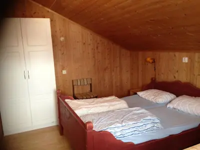 a bedroom with two beds in a wooden room at Bessheim Fjellstue og Hytter in Bessheim