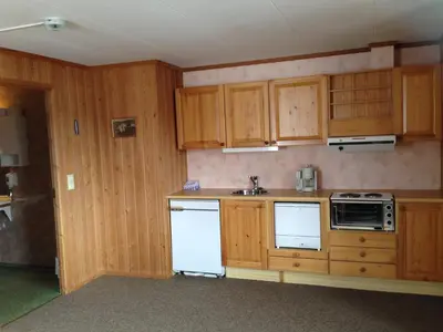 an empty kitchen with wooden cabinets and appliances at Bessheim Fjellstue og Hytter in Bessheim