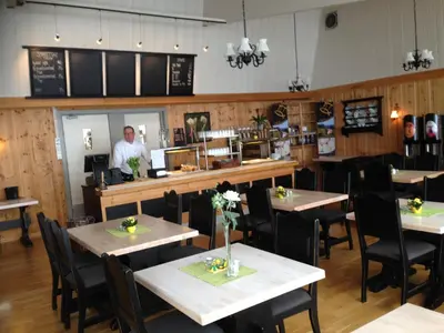 a man standing in a restaurant with tables and chairs at Bessheim Fjellstue og Hytter in Bessheim