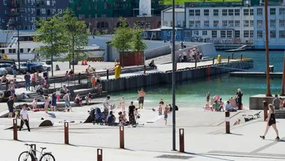 a group of people on the beach near the water at Leilighet Damsgård , nær sentrum in Bergen