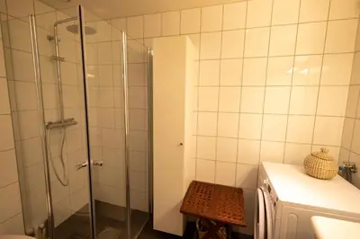 a bathroom with a shower with a glass door at Leilighet Damsgård , nær sentrum in Bergen