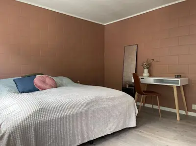 a bedroom with a bed and a desk and a chair at Leilighet i Odda sentrum in Odda