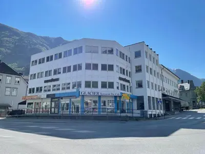 a white building on a street in a town at Leilighet i Odda sentrum in Odda