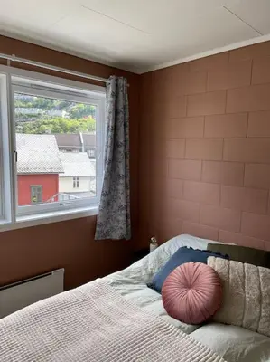 a bedroom with a bed with a large window at Leilighet i Odda sentrum in Odda