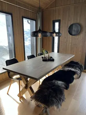 a dining room with a table and two furry chairs at Hovdetunet 77-Gaustablikk in Gaustablikk