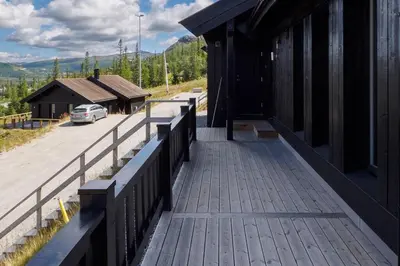 a porch of a building with a car on a road at Hovdetunet 77-Gaustablikk in Gaustablikk