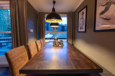 a dining room table with chairs and a lamp at Trysil Alpin 40A in Trysil