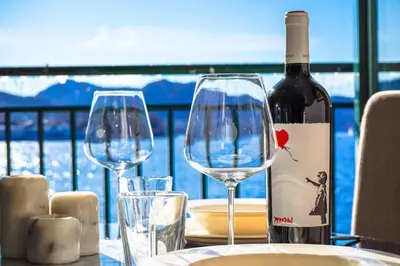 a table with two wine glasses and a bottle of wine at Central Seafront Apartments with Parking and Self Check-In! in Bergen
