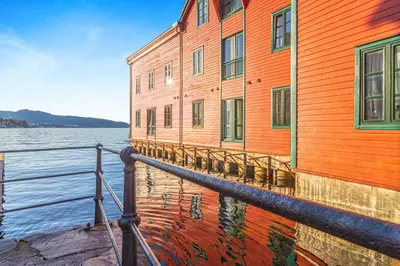 an orange building sitting next to a body of water at Central Seafront Apartments with Parking and Self Check-In! in Bergen