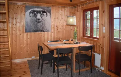 a dining room with a table and a cow on the wall at 3 Bedroom Stunning Home In Rjukan in Gaustablikk