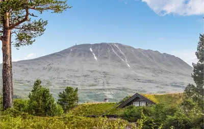 a house in the foreground with a mountain in the background at 3 Bedroom Stunning Home In Rjukan in Gaustablikk
