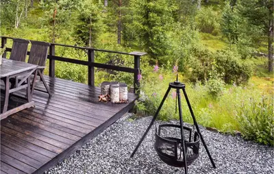 a wooden deck with a table and a dog on a tripod at 3 Bedroom Nice Home In Gol in Gol