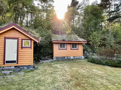 a small cabin in a yard with the sun shining at 9 person holiday home in MOSTERHAMN-By Traum in Mosterhamn