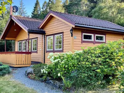 a small wooden house with a garden at 9 person holiday home in MOSTERHAMN-By Traum in Mosterhamn