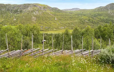 a wooden fence in a field with mountains in the background at 4 Bedroom Nice Home In Hemsedal in Hemsedal