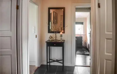 a hallway with a mirror and a table with a candle at 4 Bedroom Nice Home In Hemsedal in Hemsedal