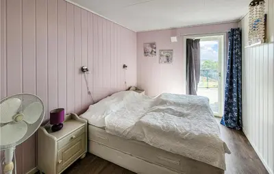 a small bedroom with a bed and a window at Nice Home In Bremnes With Wifi in Bremnes
