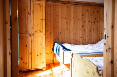 a bedroom with a bed in a wooden wall at Houmbgaarden in Røros