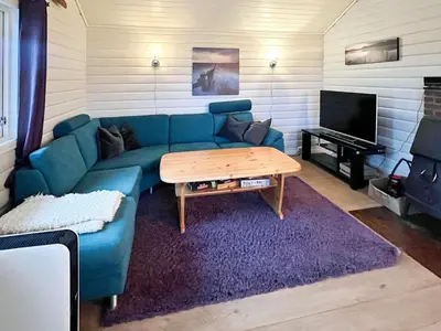 a living room with a blue couch and a table at 6 person holiday home in bremnes-By Traum in Bremnes