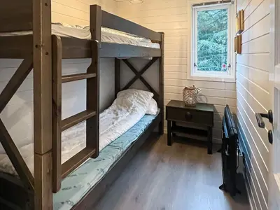 a bedroom with two bunk beds and a table at 6 person holiday home in bremnes-By Traum in Bremnes