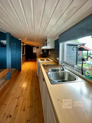 a kitchen with a sink and a counter with a window at Large cabin Sjusjøen XC ski in out & lovely view in Ringsaker
