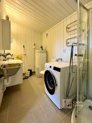 a bathroom with a washing machine and a sink at Large cabin Sjusjøen XC ski in out & lovely view in Ringsaker