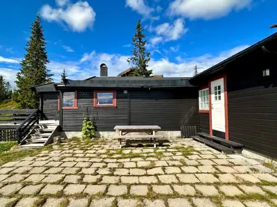 a house with a picnic table in front of it at Large cabin Sjusjøen XC ski in out & lovely view in Ringsaker