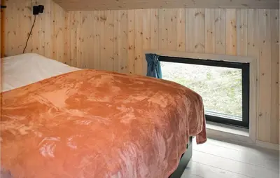 a bedroom with a large bed with a window at Cozy Home In Rauland With Sauna in Torvetjørn